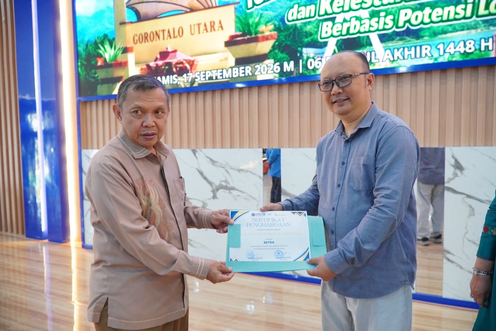 Reynold Gobel mewakili PLN Nusantara Power Unit Pembangkitan Gorontalo menerima penghargaan sebagai mitra Kuliah Kerja Dakwah (KKD) 2026 dari Rektor Universitas Muhammadiyah Gorontalo, Prof. Dr. H. Abd. Kadim Masaong, M.Pd/Hibata.id
