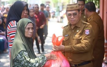 Sekda Bone Bolango Iwan Mustapa menyerahkan bahan pangan di kegiatan Pasar Murah Bersubsidi di Kecamatan Bulango Selatan, Senin (28/9/2026)/Hibata.id