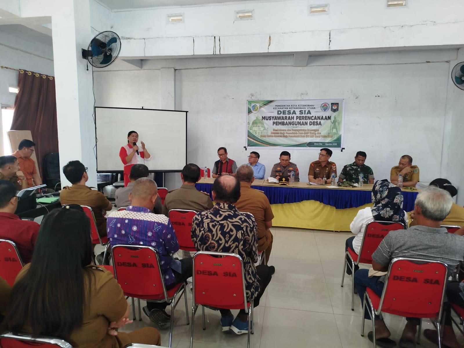 Rapat koordinasi di Balai Desa Sia, Senin, 28 September 2026. Rapat dipimpin Asisten I Bidang Pemerintahan Setda Kota Kotamobagu, Sahaya Subagio Mokoginta.