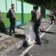 Personel Polresta Balikpapan bersama warga membersihkan sampah di kawasan Tugu Tangan Gunung Pasir setelah kegiatan nobar Indonesia melawan Thailand, Senin dini hari (5/10/2026)/Hibata.id